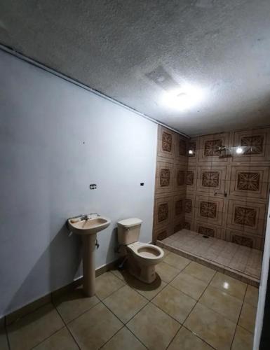 a bathroom with a toilet and a sink at Habitación completa a 2 Cuadras del Consulado EUA in Nuevo Laredo