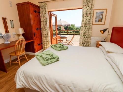 a bedroom with a bed and a desk and a window at 3 The Stables in Haven Street