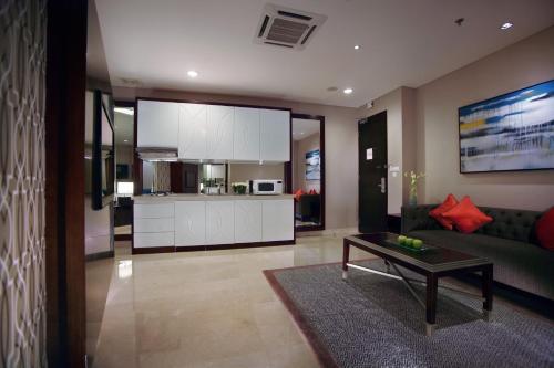 a living room with a couch and a table at The Grove Suites by Grand Aston in Jakarta