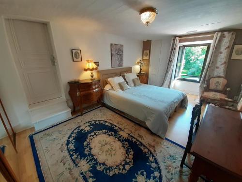 a bedroom with a bed and a window and a rug at Le Chaubier in Eyliac