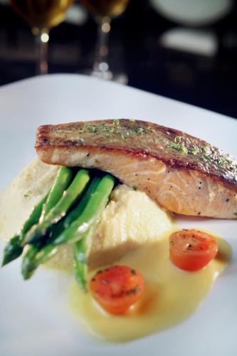 a plate of food with a piece of meat and vegetables at The Grove Suites by Grand Aston in Jakarta