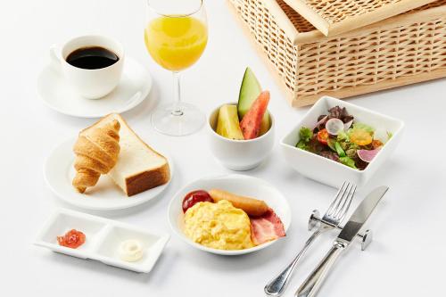 un tavolo con prodotti per la colazione e un bicchiere di vino di Relax Resort Hotel ad Atami