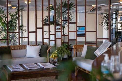 um quarto com dois sofás e uma mesa e plantas em Beach Hotel Resort em Byron Bay