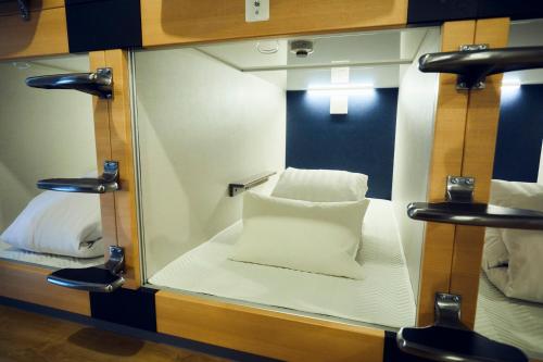 a small room with a mirror with a white pillow at ゲストハウス酒坊多満自慢 in Fussa