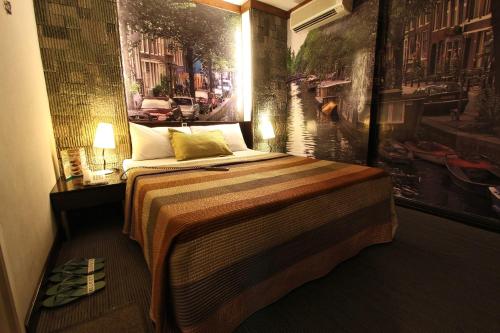 a bedroom with a bed with a painting on the wall at Eurotel North EDSA in Manila