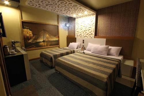 a hotel room with two beds in a room at Eurotel North EDSA in Manila