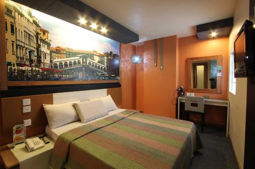 a bedroom with a bed and a painting on the wall at Eurotel North EDSA in Manila