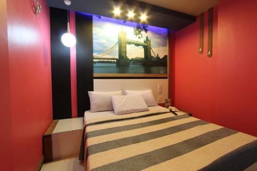 a bedroom with a bed with a painting of a bridge at Eurotel North EDSA in Manila