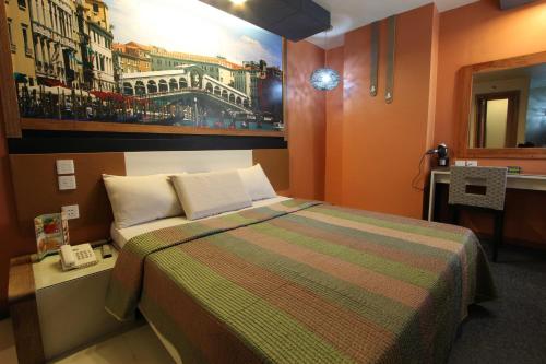 a bedroom with a bed and a painting on the wall at Eurotel North EDSA in Manila
