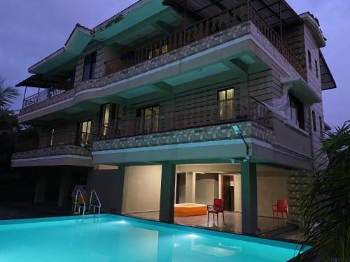 a building with a swimming pool in front of it at Neville's Villa - Pet friendly with Pool in Alibaug