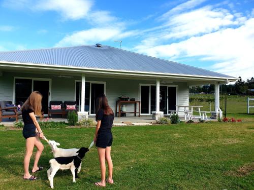 two women standing in front of a house with a dog at Fig Tree Farm B&B Highvale-Farmstay near Brisbane! in Highvale