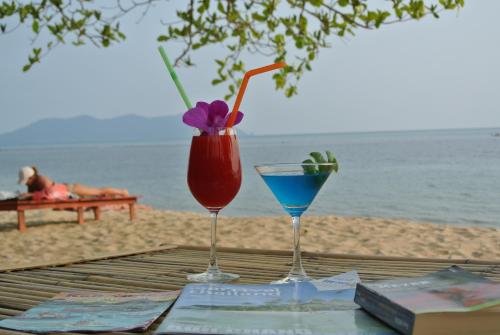 two drinks sitting on a table on the beach at Bangbaobeach Resort in Ko Chang