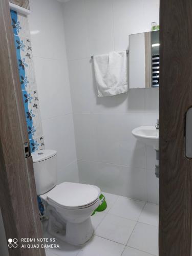 a white bathroom with a toilet and a sink at Karey 202,apartamento amoblado frente al mar in Rodadero