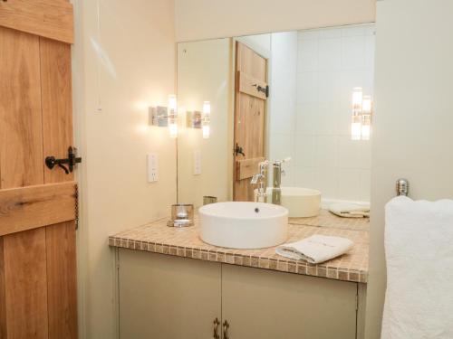 un bagno con lavandino e specchio di Gable End a High Yewdale