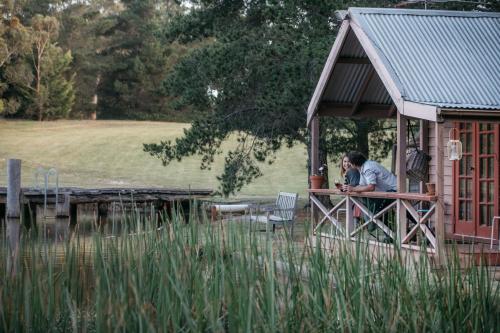two people sitting at a table in a house at Lawson Lodge Country Estate in Macedon