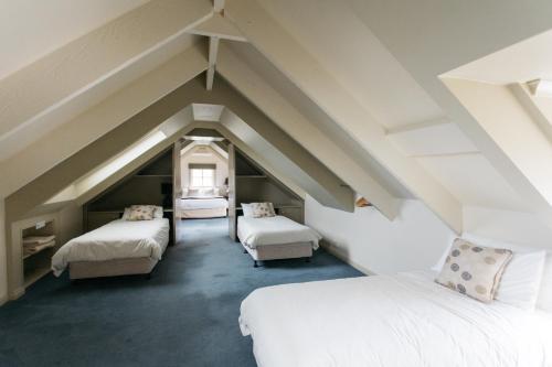 a attic bedroom with two beds and two chairs at Lawson Lodge Country Estate in Macedon