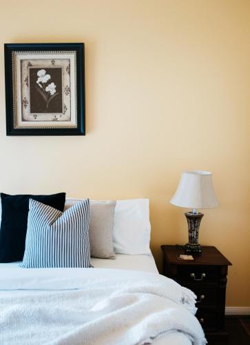a bedroom with a bed and a table with a lamp at Lawson Lodge Country Estate in Macedon