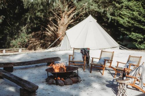 a tent with chairs and a fire in front of it at Lawson Lodge Country Estate in Macedon