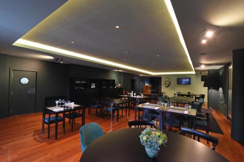 ein Restaurant mit Tischen und Stühlen in einem Raum in der Unterkunft Hotel Vila Luena in Vila Verde