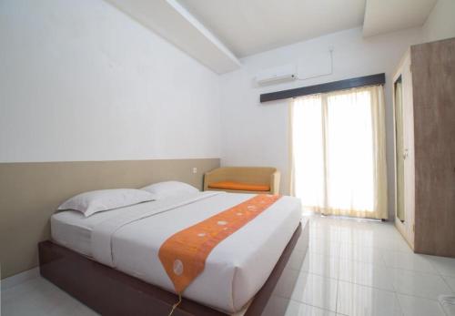 a bedroom with a large bed and a window at Adikara Renon in Denpasar