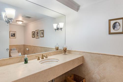 a bathroom with a sink and a large mirror at Oceanview Penthouse Suite in Honolulu