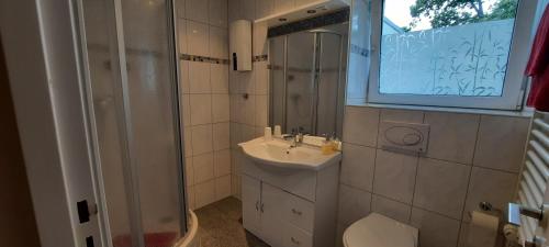 een badkamer met een wastafel, een douche en een toilet bij Miles Hotel Berlin in Berlijn