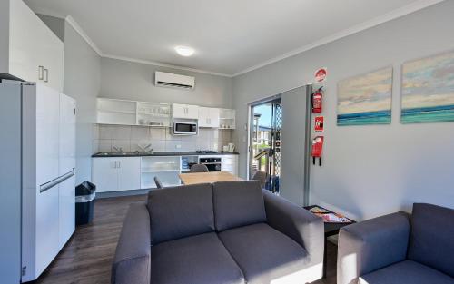 uma sala de estar com um sofá e uma cozinha em Harvest Stay Cabin Park em Port Augusta