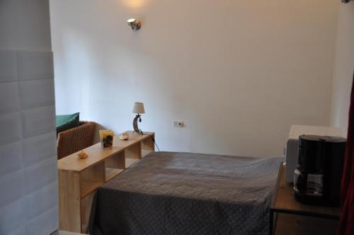een kleine slaapkamer met een bed en een televisie bij location studio meublé avec jardin in Sorgues
