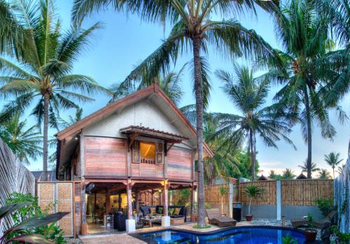 a house with a pool and palm trees at Villas SAMALAMA Gili Trawangan in Gili Trawangan