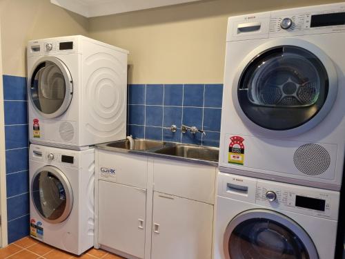 a kitchen with two washing machines and a sink at Blue Wren Lodge Waratah in Newcastle