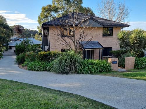 a house with a driveway in front of it at Blue Wren Lodge Waratah in Newcastle