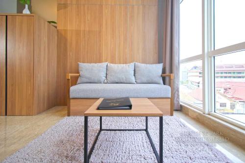 a room with a bed with a table and a window at Menteng Park Exclusive Emerald in Jakarta