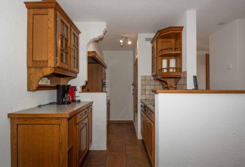 a kitchen with wooden cabinets and a white refrigerator at Ferienwohnung Senggi in Adelboden