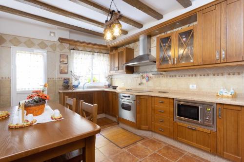 a large kitchen with wooden cabinets and a table at Home2Book Charming Apartment Los Realejos in Los Realejos