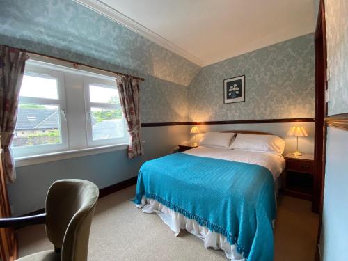 1 dormitorio con cama, ventana y silla en Kings Arms Hotel, en Lockerbie