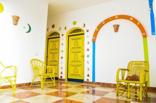 a room with two yellow doors and chairs at Fadlos Anay Nubian Guesthouse فضلوس أناي in Aswan