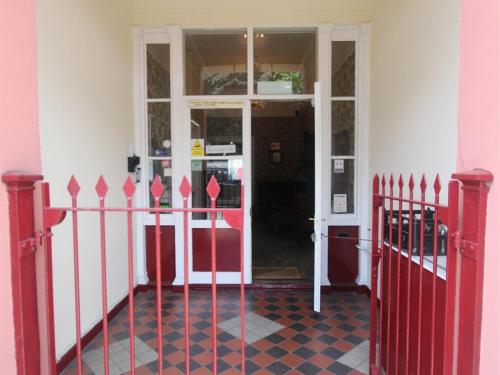een ingang naar een gebouw met een rood en wit hek bij Spring Garden Guest House in Gosport