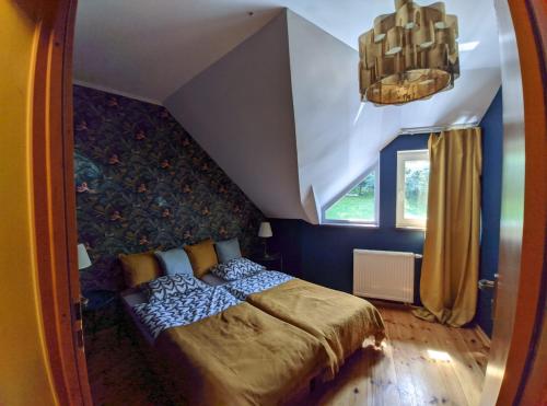 - une chambre avec un lit dans une pièce bleue dans l'établissement Villa Idylla, à Przesieka