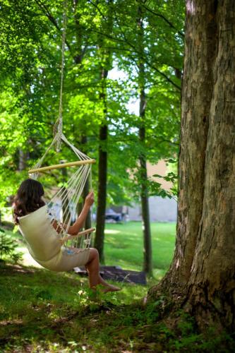 a little girl sitting in a hammock in a tree at Villa Idylla in Przesieka
