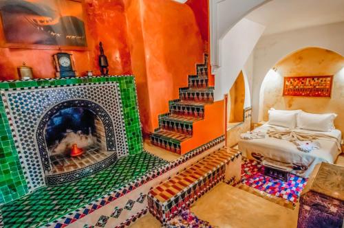 a room with a fireplace with a bed and a stair at Riad Chorfa in Marrakesh