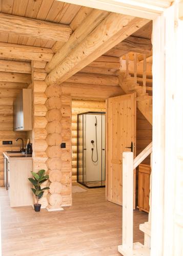 a wooden house with a staircase in a kitchen at Na Wzgórzu Domki z Bali -Jacuzzi, Balia, Spa in Polańczyk