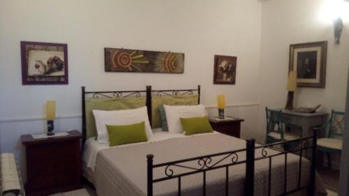 una camera da letto con un grande letto con cuscini verdi di Sa Corte Nova a Lula