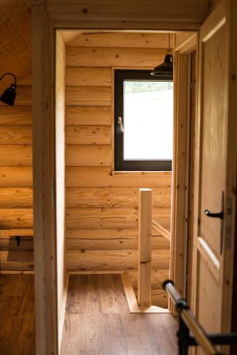 a room with a window in a wooden house at Na Wzgórzu Domki z Bali -Jacuzzi, Balia, Spa in Polańczyk
