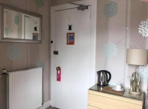 a kitchen with a white door and a table with a lamp at The Stag Head Hotel in Edinburgh