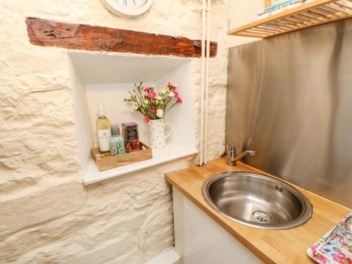 a tiny bathroom with a sink and a counter at October Cottage in Crook