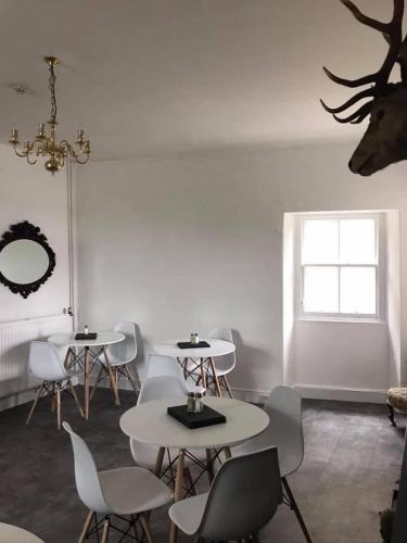 a white room with tables and chairs and a window at The Stag Head Hotel in Edinburgh