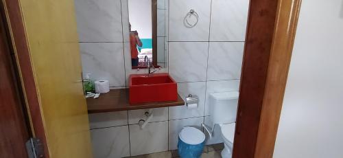 a bathroom with a red sink and a toilet at Pedra do Sol Pousada in Alter do Chao
