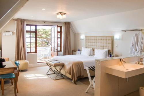 ein Hotelzimmer mit einem Bett und einem Bad in der Unterkunft Harbour House Hotel - Manor House in Hermanus