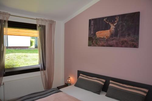 a bedroom with a bed and a deer on the wall at Ferienhaus Starenweg 6 in Eichbach