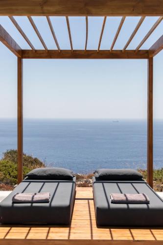 two beds on a deck with a view of the ocean at Kouros Exclusive Hotel & Suites - Adults Only in Faliraki